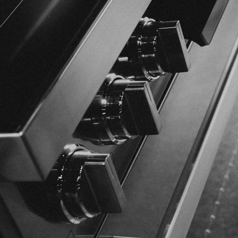 Schwarze Kochknöpfe an einem modernen Küchenherd.